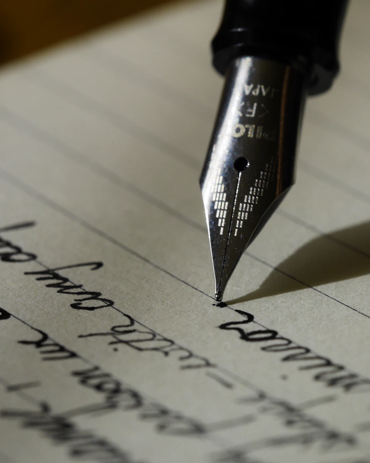 Vulpen die op gelijnd papier schrijft, in warm strijklicht